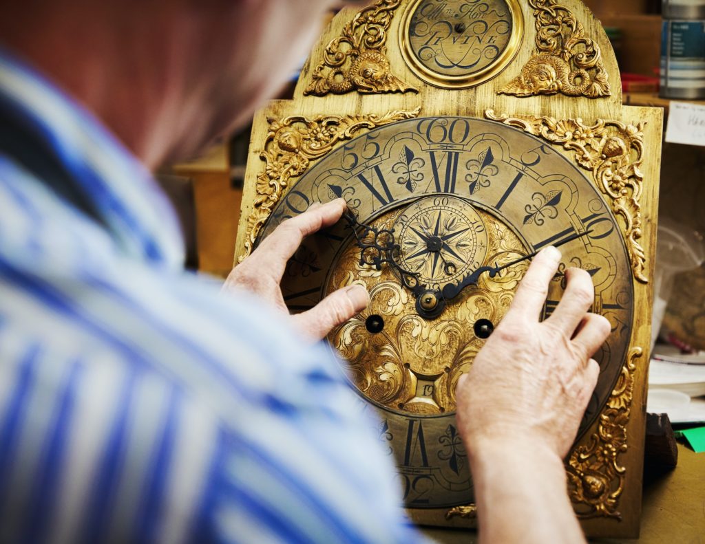 A clock maker working on antique clock