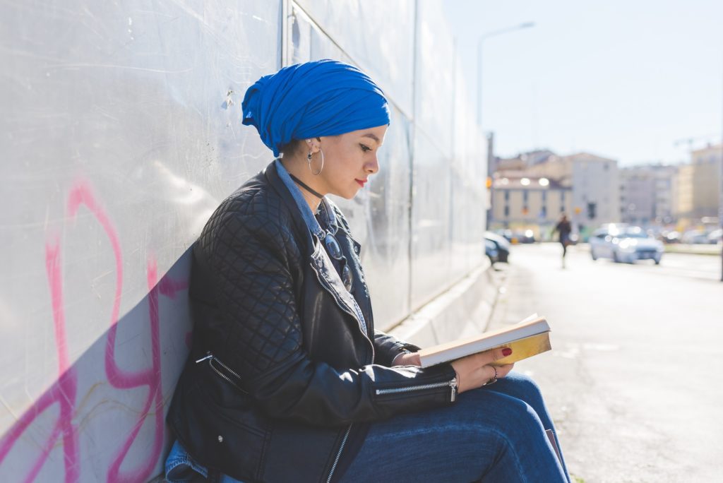 Arabian young woman wearing hijab outdoor reading book